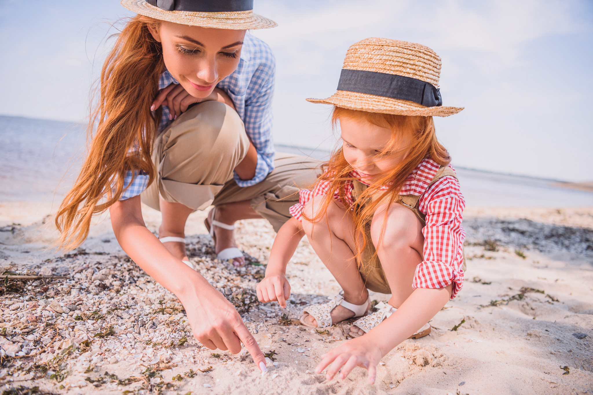 Mutter spielt mit ihrem Kind am Sandstrand