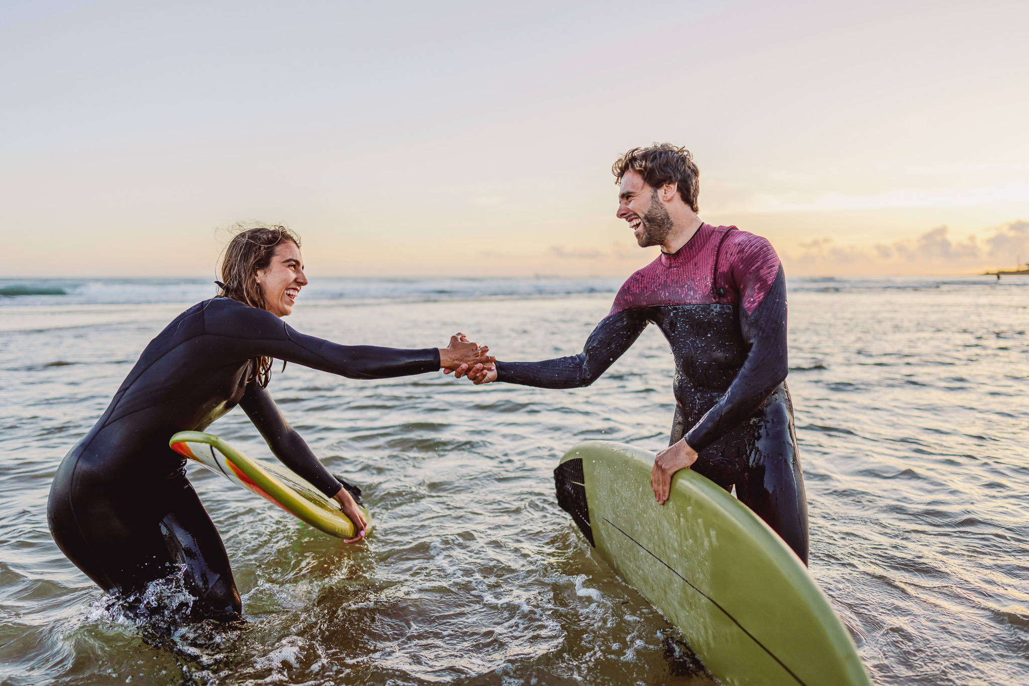 Zwei Surfer reichen sich die Hände