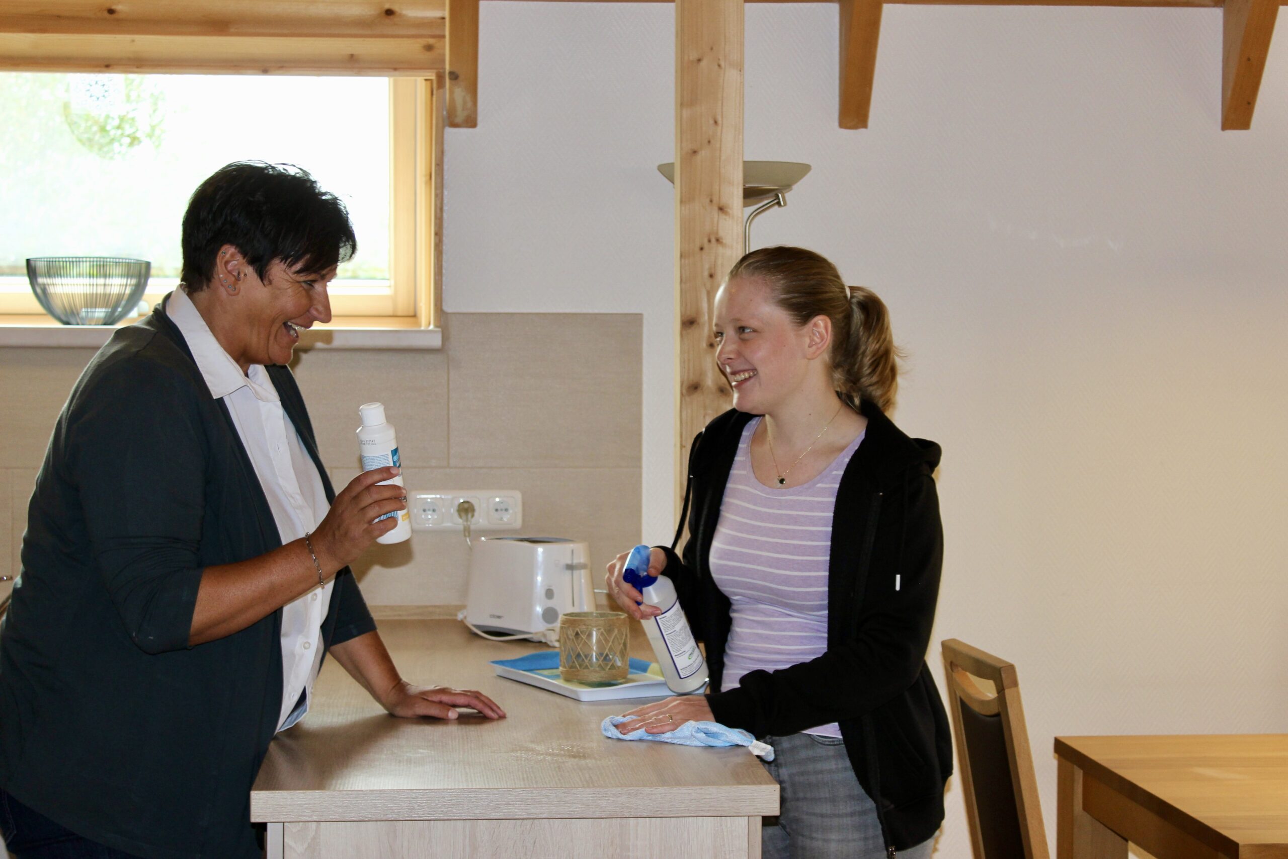 Zwei Hausdamen in einem Ferienhaus mit Reinigungsmitteln in der Hand