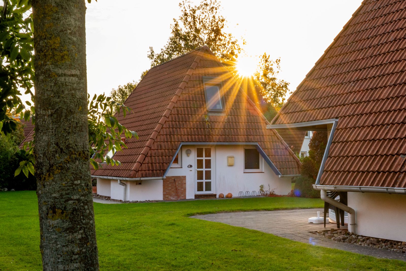Sonnenstern hinter einem Ferienhaus in Dorum-Neufeld